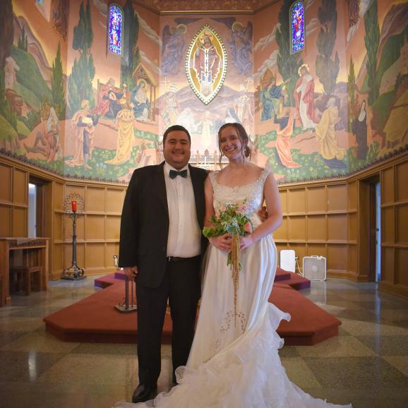 a bride and groom at the altar in christ the king chapel