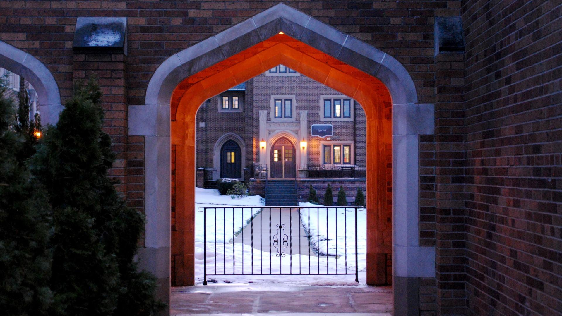 Egan hall as seen through old main archway in winter