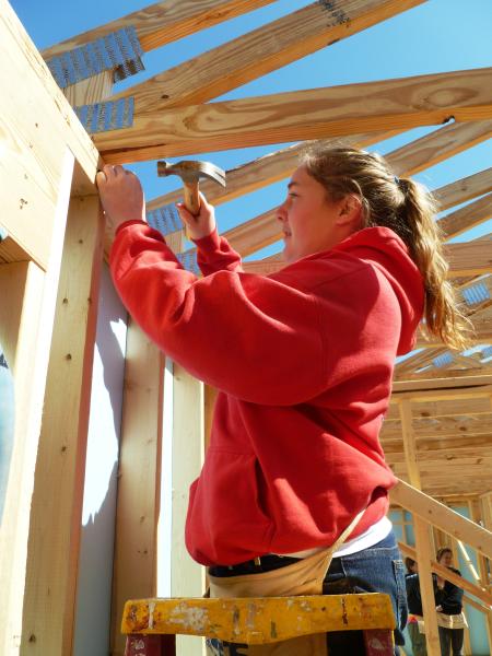 a female student helps build a house 